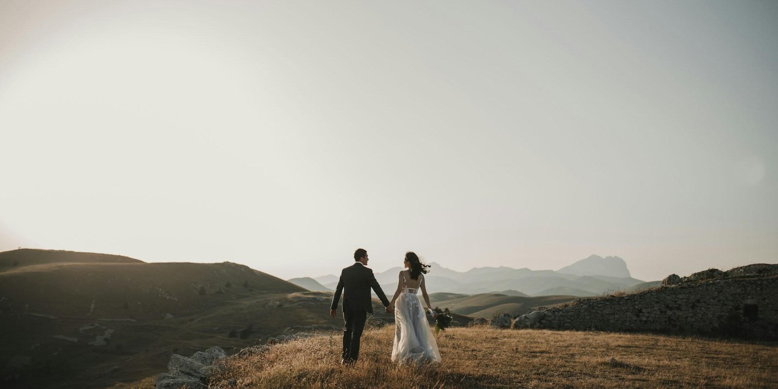 A couple walking a hillside at the end of the day
